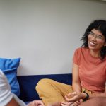 A coach and a client sitting and talking in a one-on-one coaching session