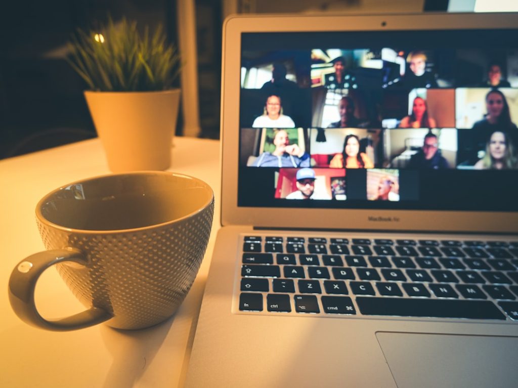 A laptop screen showing a woman on a video call during an online coaching session - the kind of conversation an AI notetaker records and summarizes.