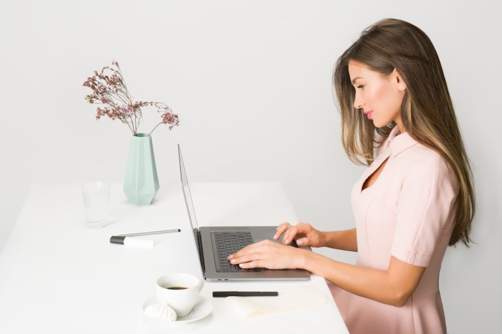 A coach working in coaching software at a bright desk.