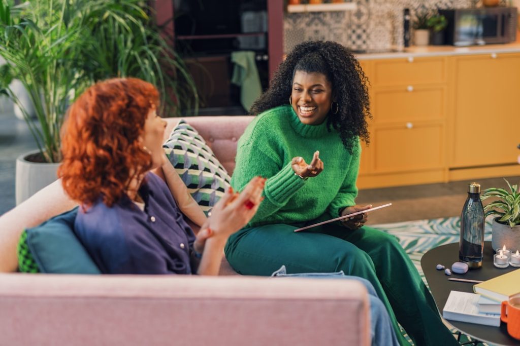 A wellness coach and client sitting together in a relaxed one-on-one coaching conversation.