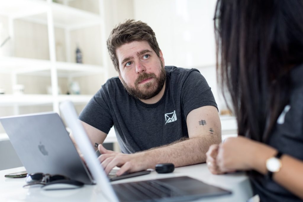A coach and a client reviewing coaching software together on a laptop