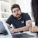 A coach and a client reviewing coaching software together on a laptop