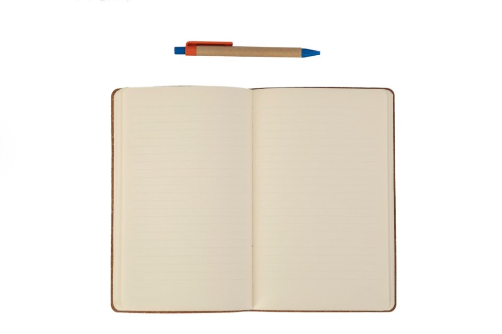 An open blank notebook with cream lined pages lying flat, a kraft-paper ballpoint pen with blue and orange trim resting above it, on a plain white background.