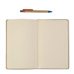An open blank notebook with cream lined pages lying flat, a kraft-paper ballpoint pen with blue and orange trim resting above it, on a plain white background.